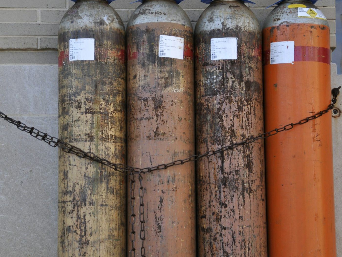 Industrial gas cylinders chained in a row awaiting testing